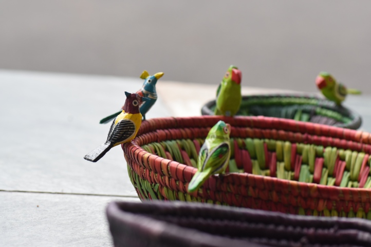 Parrots perched on handmade baskets
